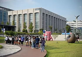 Students queue in front of Bellygom to take pictures at Yonsei University's Sinchon campus on Thursday. [ALLAND DHARMAWAN]