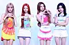 Four members of Hearts2Hearts pose in colorful outfits against a plain backdrop.
